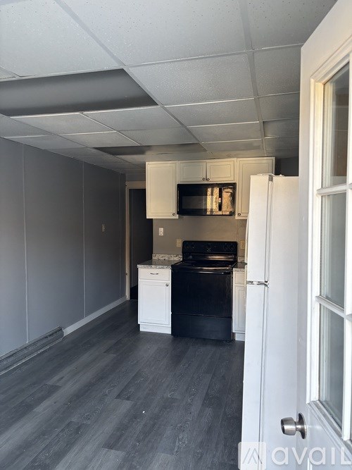 A kitchen with a black oven and white cabinets.
