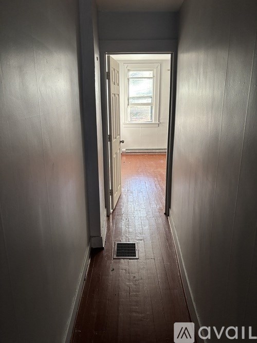 A long, narrow hallway with a door at the end.