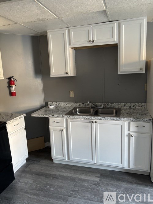 A kitchen with white cabinets and a marble countertop.