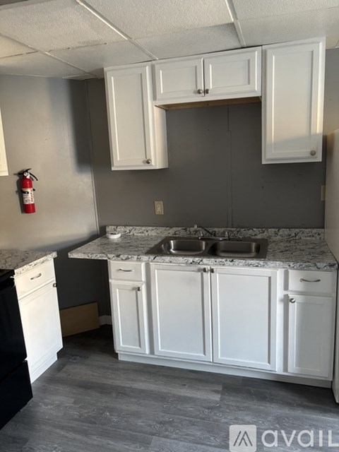 A kitchen with white cabinets and a marble countertop.