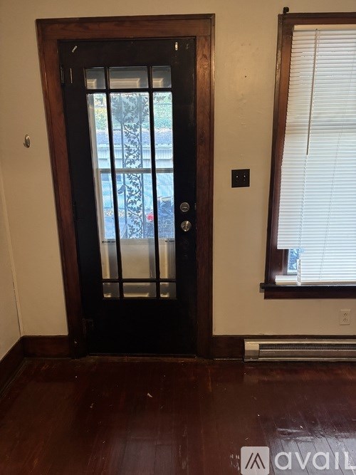 A black door with a glass window in the middle.