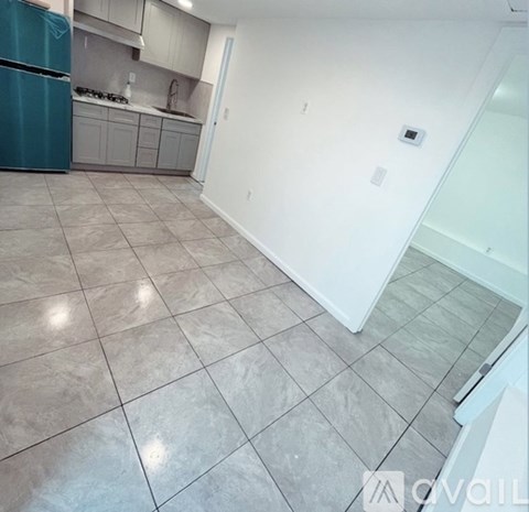 A kitchen with a blue refrigerator and white walls.