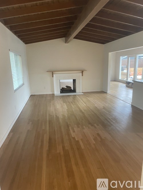 A room with wooden floors and a fireplace.