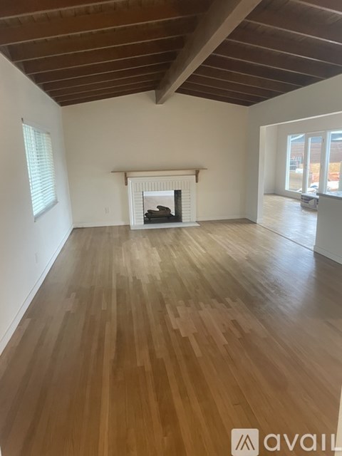 A room with wooden floors and a fireplace.