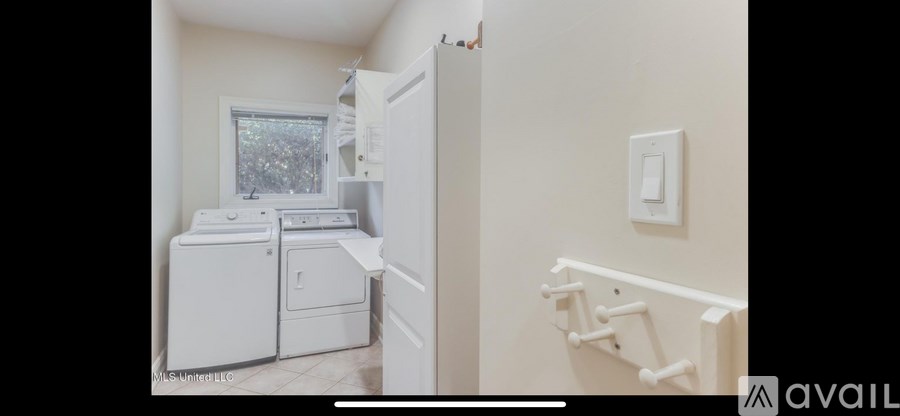 A white laundry room with a washer and dryer.