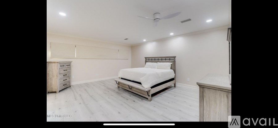 A bedroom with a bed, dresser, and nightstand.