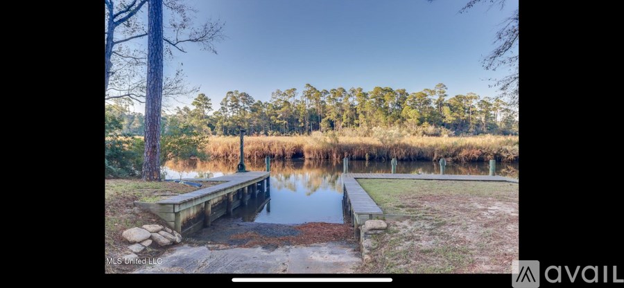 A serene lake surrounded by trees and a wooden dock.