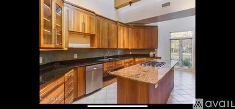 A kitchen with wooden cabinets and a granite countertop.