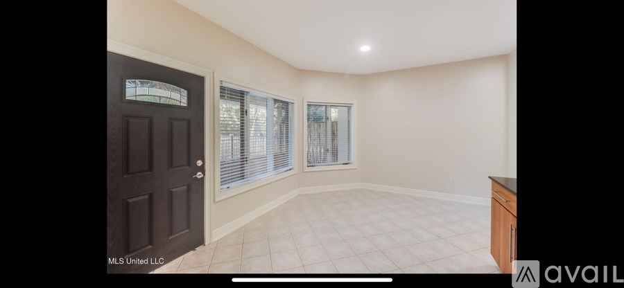 A room with a brown door and a window with blinds.