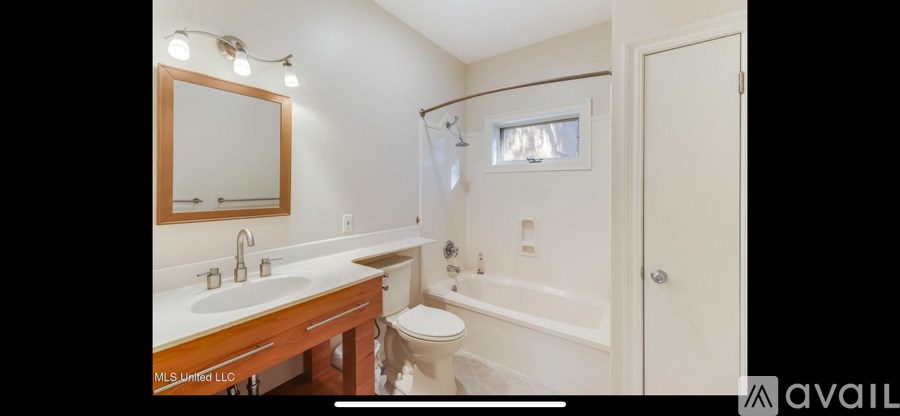 A bathroom with a toilet, sink, and bathtub.