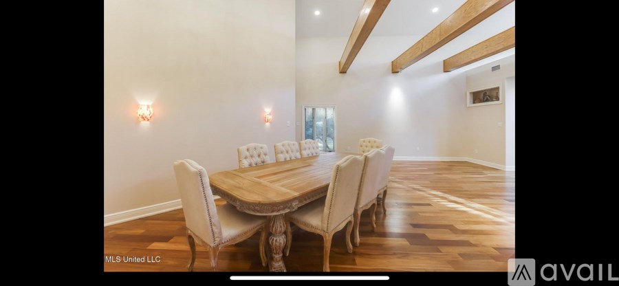 A dining room with a wooden table and chairs.