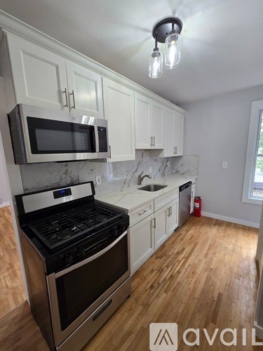 A kitchen with a stove, microwave, and cabinets.