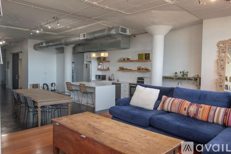 A living room with a blue couch and a wooden coffee table.