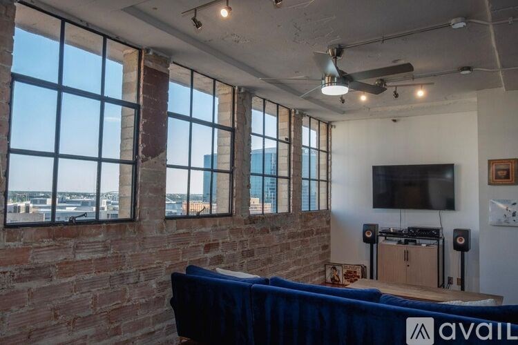 A room with a brick wall and a ceiling fan.