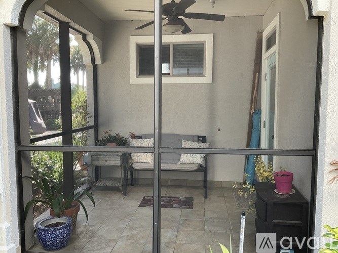 A patio with a table and chairs and a fan.