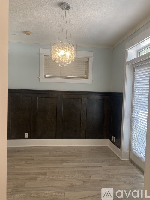 A white building with a balcony and a garden in front.