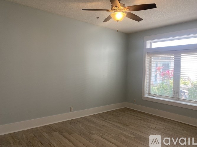 A room with a ceiling fan and a window with blinds.