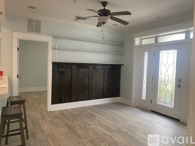 A room with a ceiling fan and wooden flooring.