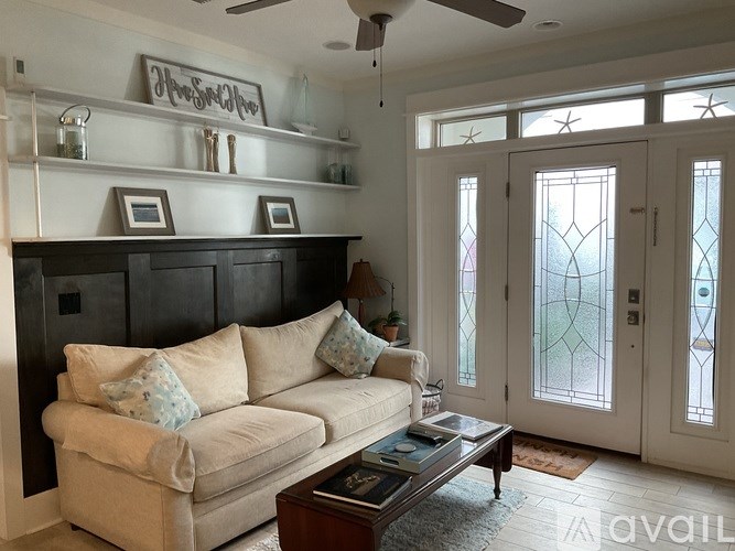 A living room with a beige couch and a coffee table.