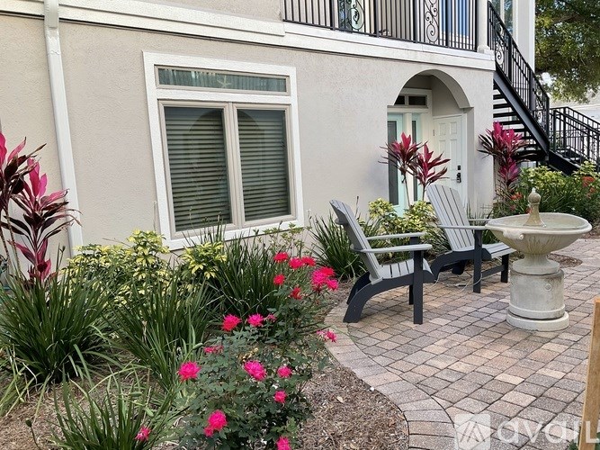 A patio with a bench, table, and a fountain.