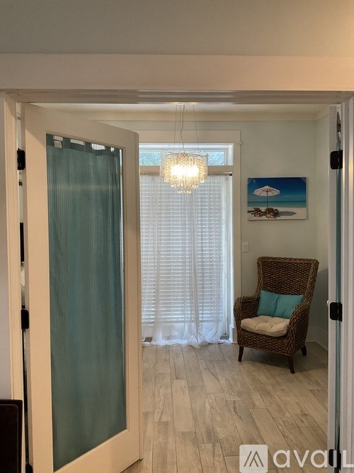 A room with a chair and a painting on the wall.