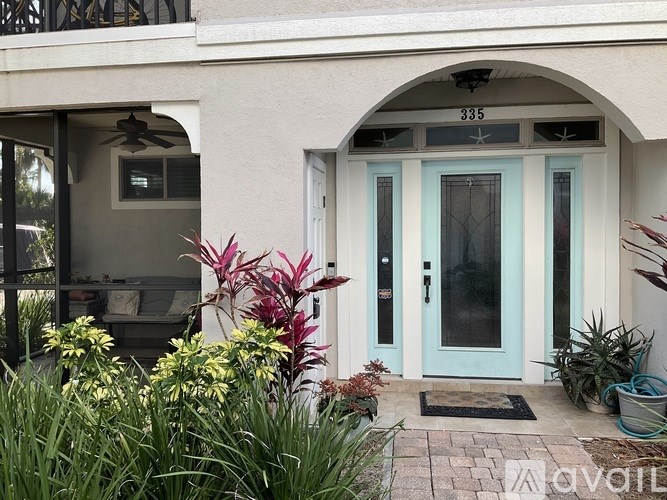 A blue door is on the right side of a white building.