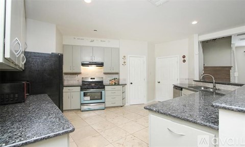 A kitchen with granite countertops and white cabinets.