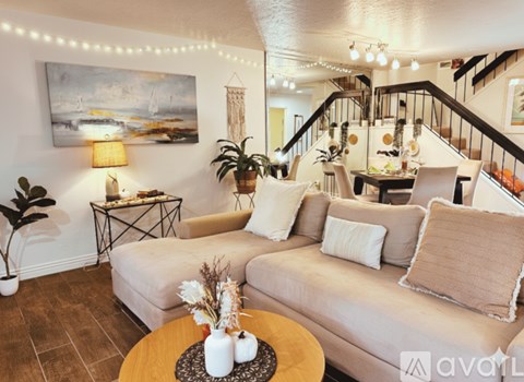 A living room with a couch, a table, and a painting on the wall.