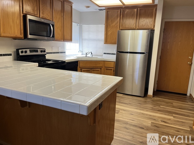 A kitchen with wooden cabinets and a white counter top.