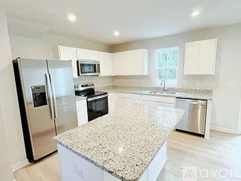 A kitchen with a granite countertop and stainless steel appliances.