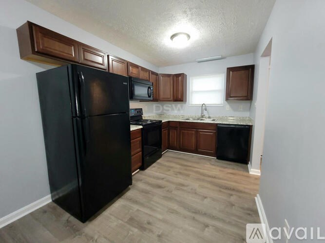 A kitchen with black appliances and wooden cabinets.