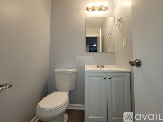 A white toilet and sink in a small bathroom.