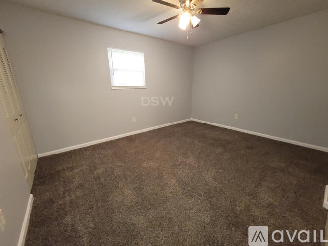 A room with a ceiling fan and a window.