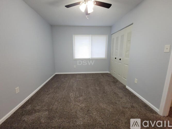 A room with a ceiling fan and a window.