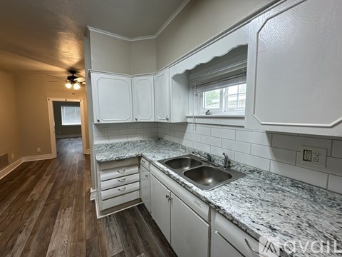 A kitchen with white cabinets and a granite countertop.