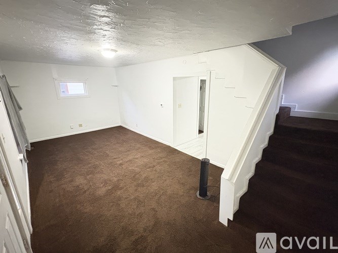 A room with a staircase and a window.