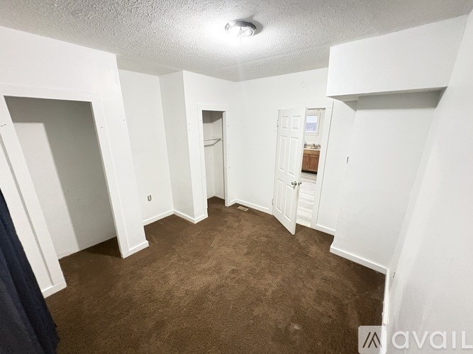 A room with white walls and a brown carpet.