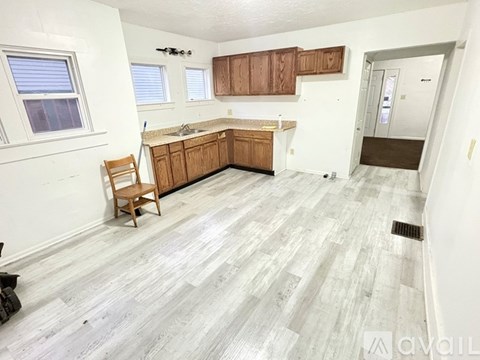 A kitchen with wooden cabinets and a grey floor.