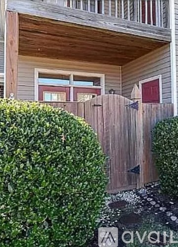 A wooden house with a red door and windows.