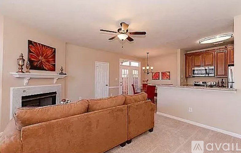 A living room with a brown couch and a fireplace.