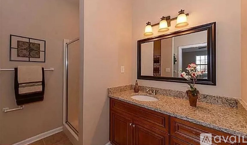 A bathroom with a marble countertop and a framed picture on the wall.