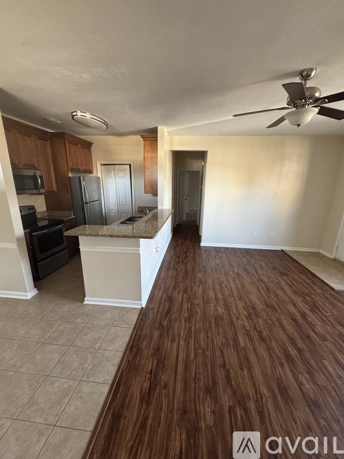 A room with a wooden floor and a ceiling fan.