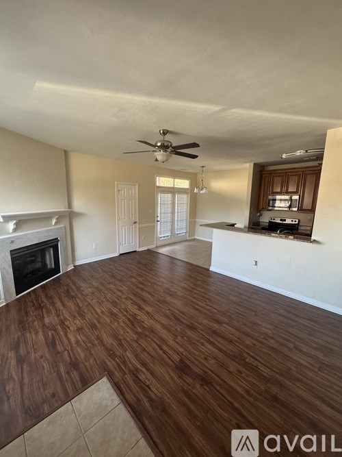 A living room with a fireplace and a ceiling fan.