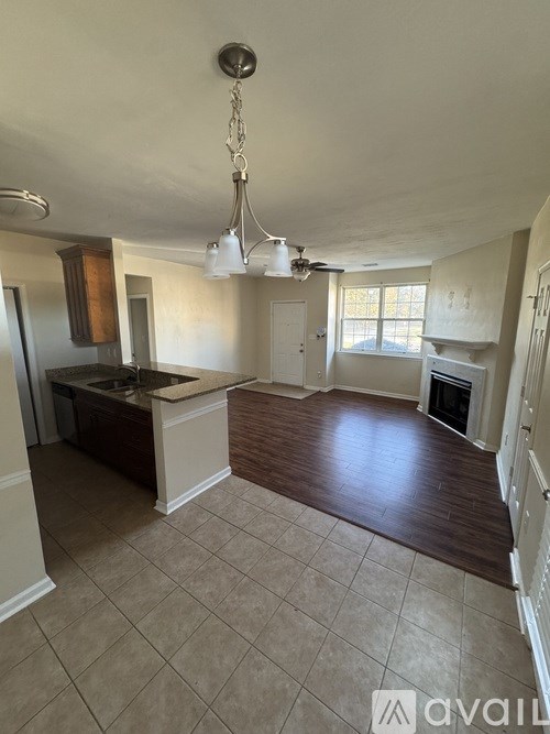 A kitchen with a sink, stove, and a window.