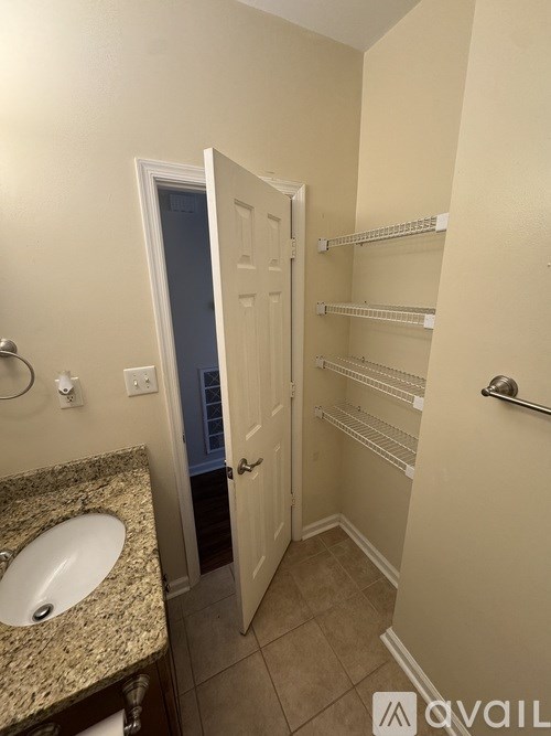 A bathroom with a sink, towel rack, and a door.