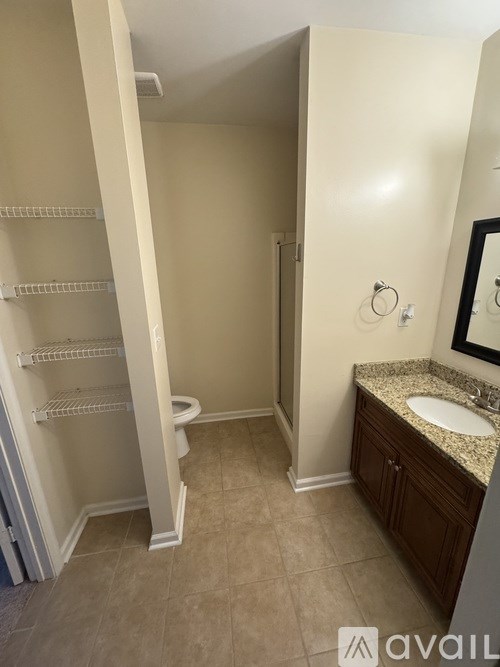 A bathroom with a toilet, sink, and a mirror.