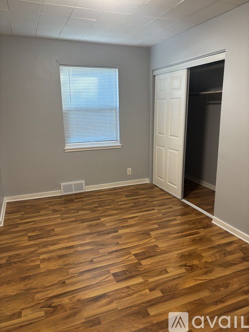 A room with wooden flooring and a white door.