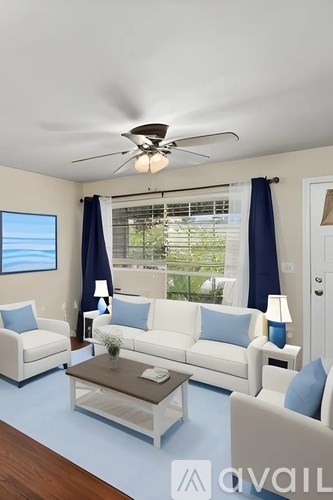 A living room with a white couch, a brown coffee table, and a ceiling fan.