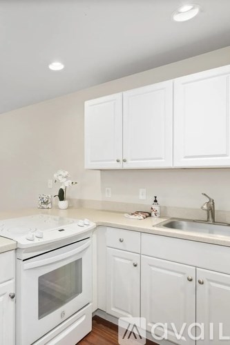 A kitchen with white appliances and cabinets.