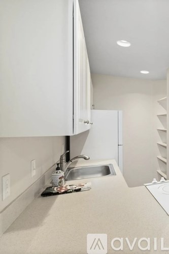 A kitchen with white cabinets and a sink.